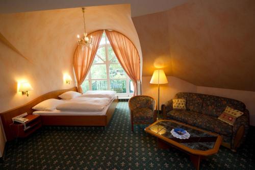 une chambre d'hôtel avec un lit et un canapé dans l'établissement Landgut Stemmen, à Stemmen