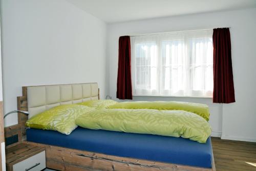 シュクオルにあるMinchületta 1の窓、黄色と青のシーツが備わるベッド1台