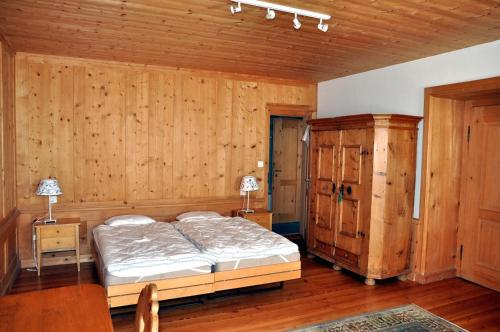 a bedroom with a bed and a wooden wall at Chasa Schucany in Ftan