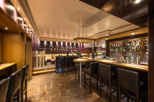 a bar with black chairs in a restaurant at MUNTE - Wellnesshotel am Stadtwald in Bremen