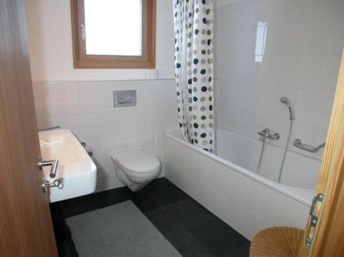a bathroom with a toilet and a tub and a sink at Craista 5 in Scuol