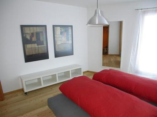 a living room with two red beds and a window at Craista 5 in Scuol
