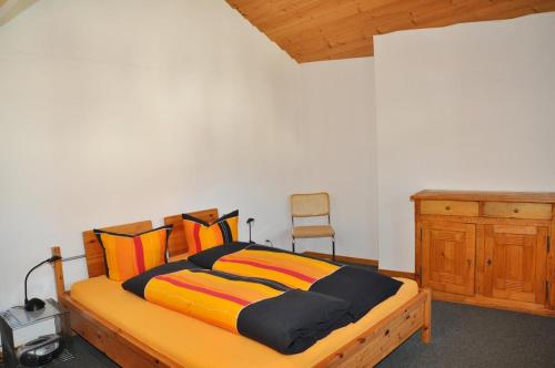a bedroom with a wooden bed with a desk and a chair at Plazzöl Suol Nr. 5 in Scuol