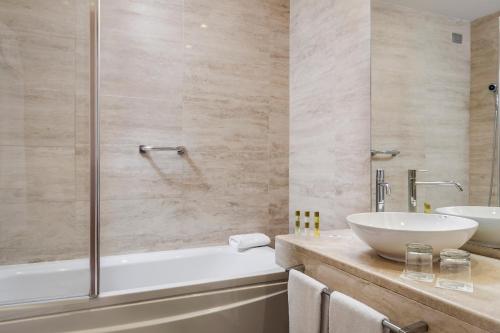 y baño con bañera, lavamanos y ducha. en Eurostars Roma Aeterna en Roma