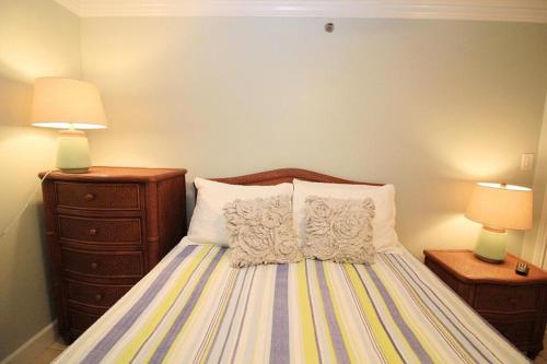 a bedroom with a bed with two lamps and two pillows at TradeWinds 102 in Romar Beach