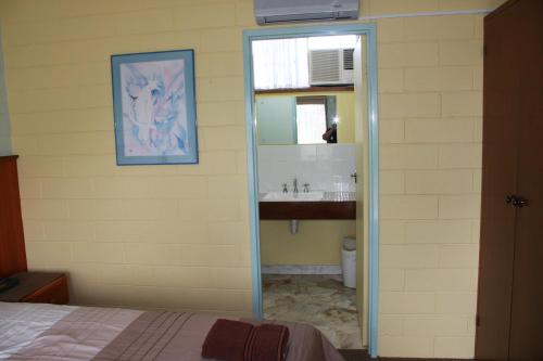 a bathroom with a sink and a mirror at Opal Motel in Leongatha