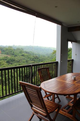 a porch with a wooden table and chairs on a balcony at Nkutu River Lodge in Kloof