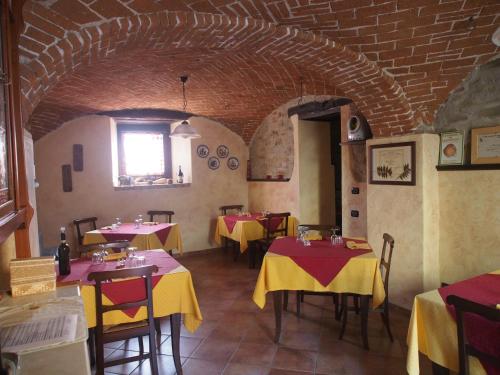 a restaurant with tables with yellow and red table cloth at Agriturismo Tenuta Antica in Cessole