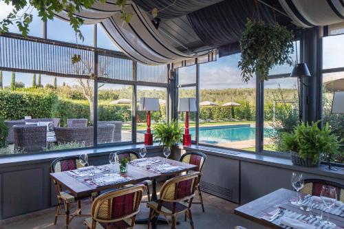 a dining room with a table and chairs and a pool at Locanda Rossa in Capalbio