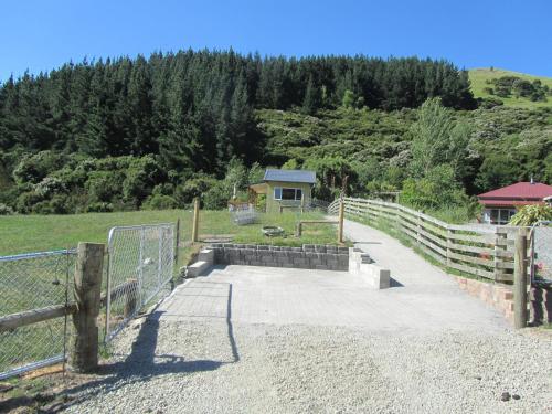 a gate with a fence next to a field at Snowberry Cottage at Lochsloy Farm Little River in Little River