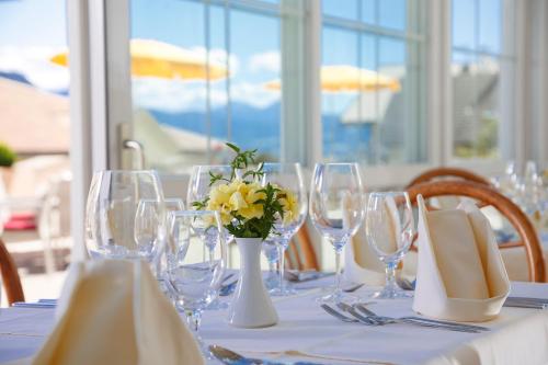 a table with wine glasses and a vase with yellow flowers at Sonnenhotel Adler Spa & Nature Adults only in Villandro