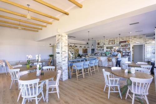 a restaurant with tables and chairs and a bar at Sun Village Hotel Apartments in Megás Limniónas