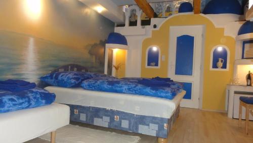 two beds in a room with a painting on the wall at Resort Svět in Úžice