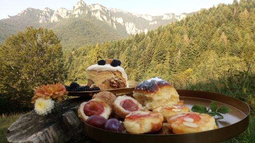 a plate of pastries and a cake with mountains in the background at Pensiunea Bia Papadia in Bicaz
