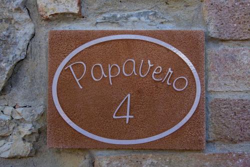 a sign on a brick wall with the number four at Agriturismo Le Gallozzole in Monteriggioni
