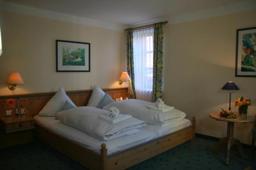 a bedroom with a bed with two pillows on it at Hotel - Landgasthof Obermaier Zum Vilserwirt in Altfraunhofen
