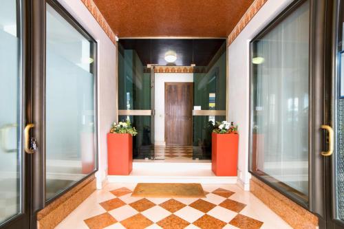 un pasillo con puertas naranjas y suelo a cuadros en Holiday Treviso Suite Venezia, en Treviso
