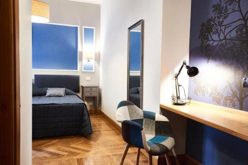 una camera con letto, scrivania e specchio di Domus Cavour Guest house a Roma