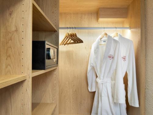 a white robe hanging on a rack in a kitchen at Hotel Tirol Fiss 4Sterne Superior in Fiss