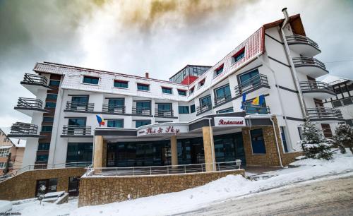 a hotel in the snow in front of a building at Hotel Ski&Sky in Predeal