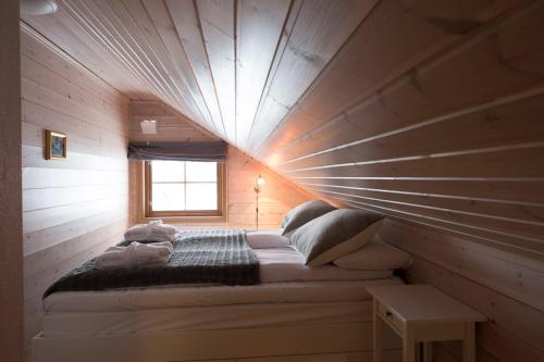 a room with a bed in a wooden wall at Skarsnuten Apartments in Hemsedal