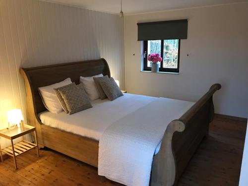 een slaapkamer met een bed met witte lakens en een raam bij Molenaarswoning in Beek