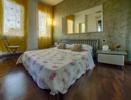 une chambre avec un lit et un miroir au mur dans l'établissement Holiday Treviso Attico Vittoria, à Trévise