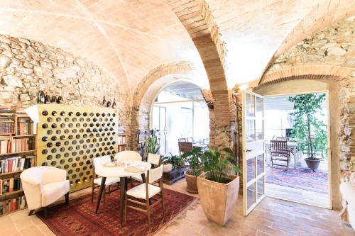 a room with a table and chairs and a stone wall at Agriturismo Podere L'Agave in San Vincenzo