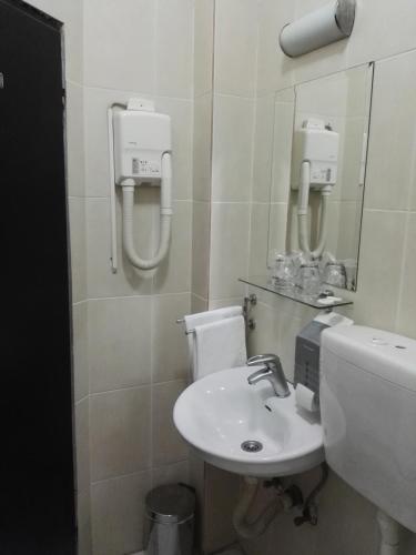 a white bathroom with a sink and a toilet at Guest House Amico in Vranje