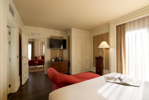a living room filled with furniture and a tv at Hotel Sevilla Center in Seville