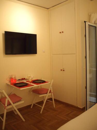 een kamer met een bureau en een televisie aan de muur bij Charming Studio Posh Quartier (Kolonaki Athens) in Athene