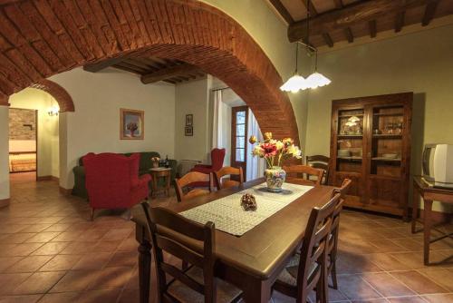 a dining room with a table and chairs and a living room at Agriturismo Le Gallozzole in Monteriggioni