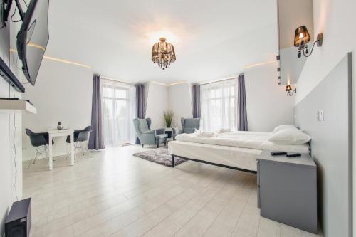 ソポトにあるApartamenty Sun & Snow Sopocka Przystańの白いベッドルーム(ベッド1台、テーブル、椅子付)