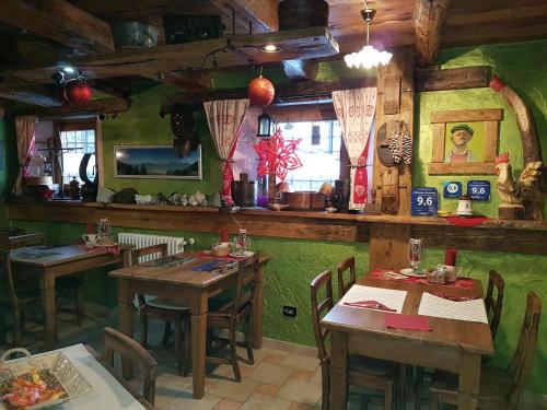 un ristorante con tavoli in legno e pareti verdi di Affittacamere Saint Salod a Charvensod