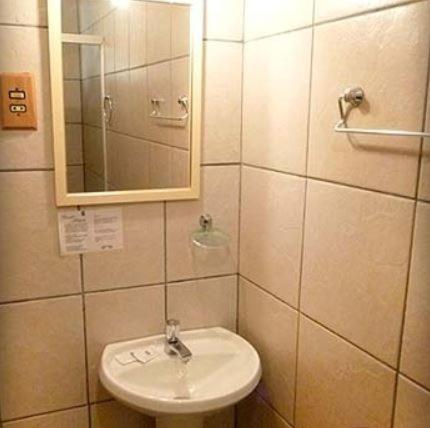 a bathroom with a sink and a mirror at Hotel Primavera in Bento Gonçalves