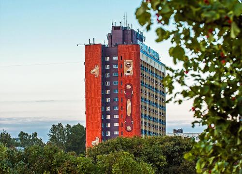un edificio alto rojo con un reloj en él en Art Hotel Karelia, en San Petersburgo