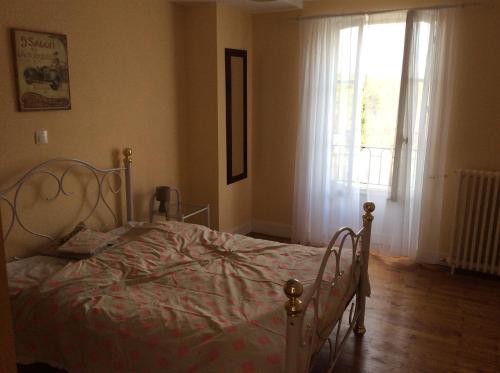 1 dormitorio con cama y ventana en Le Petit Bijou en Saint-Fraigne