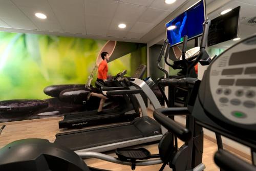 a gym with a woman running on a treadmill at Hotel Sevilla Center in Seville