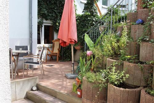 a patio with a red umbrella and some plants at Karuna Haus in Bad Windsheim
