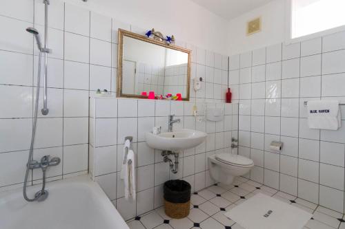 a bathroom with a sink and a toilet and a mirror at Blue Haven Hotel - Bacolet Bay - Tobago in Scarborough