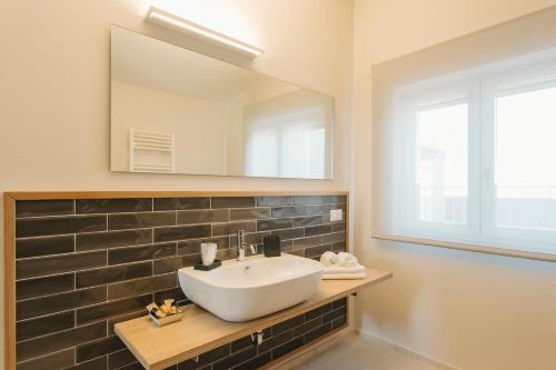 a bathroom with a sink and a mirror at Livingstone B&B in Matera