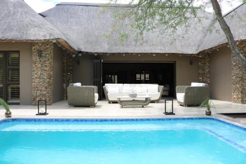 a swimming pool in front of a villa at Luvivane Luxury Villa in Marloth Park