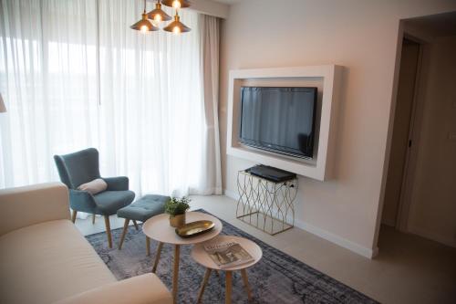 a living room with a couch and a tv at Suite Caesar - Neot Golf in Caesarea