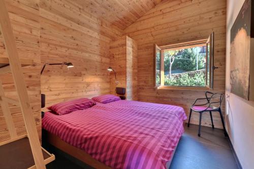 ヴェルビエにあるCrescendo 208の木造キャビン内のベッド1台が備わるベッドルーム1室を利用します。