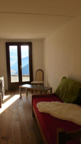 a room with a bed and a table and a window at Appartment Emosson in Finhaut