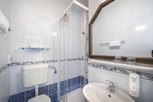 a bathroom with a sink and a toilet and a mirror at Laguna Maradiso Hotel by Aminess in Novigrad Istria
