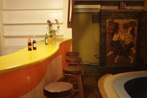 a bathroom with a bar with stools and a painting at Suanmali Samui in Lamai