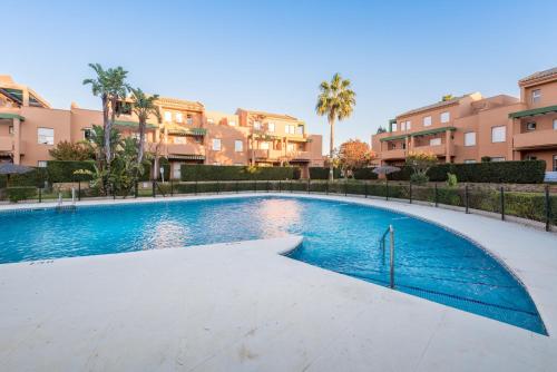 una piscina con edificios de fondo en Apartamento Mijares, en Chiclana de la Frontera