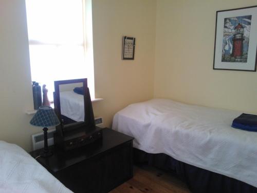 A bed or beds in a room at Manannan Cottage, Beara