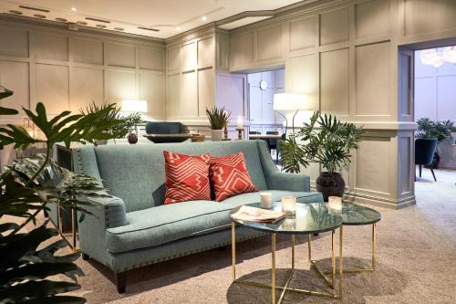 a living room with a blue couch and a table at Home Hotel Temperance in Malmö